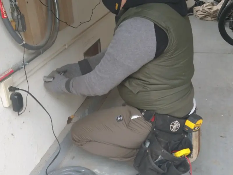 Electrician performing outlet wiring in a Crystal Springs garage